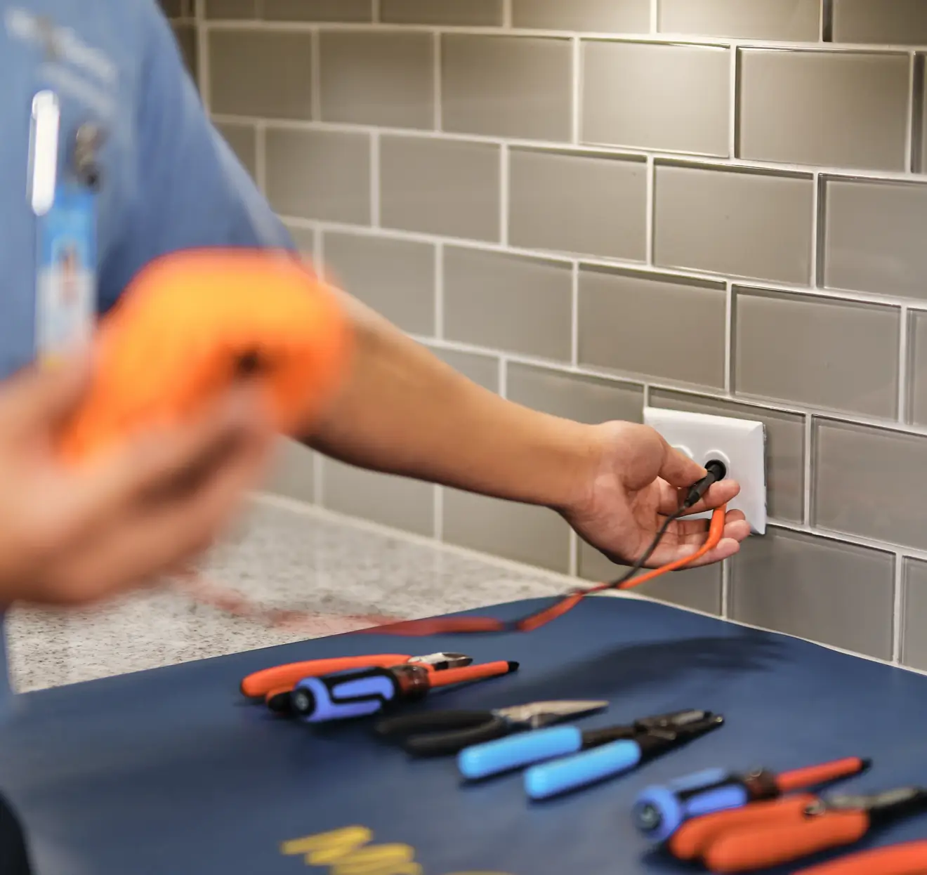 Electrician testing kitchen outlet during home electrical inspection