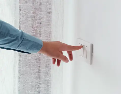 Hand flipping on a light switch.
