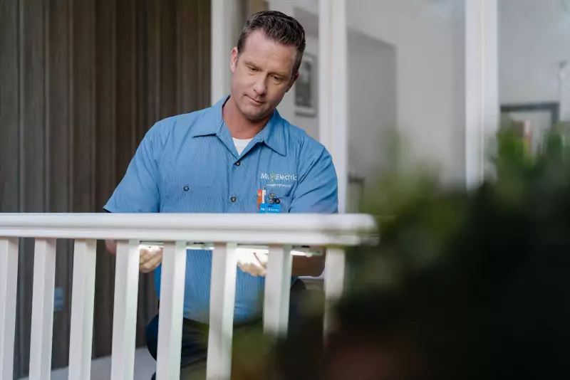 A Mr. Electric electrician installing lighting on a piece of deck railing in Savannah, GA.