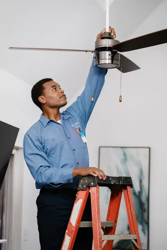 A Mr. Electric electrician installing a ceiling fan in Houston, TX.