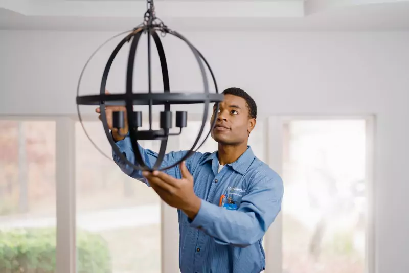 Mr. Electric of Lake County electrician installing a chandelier.
