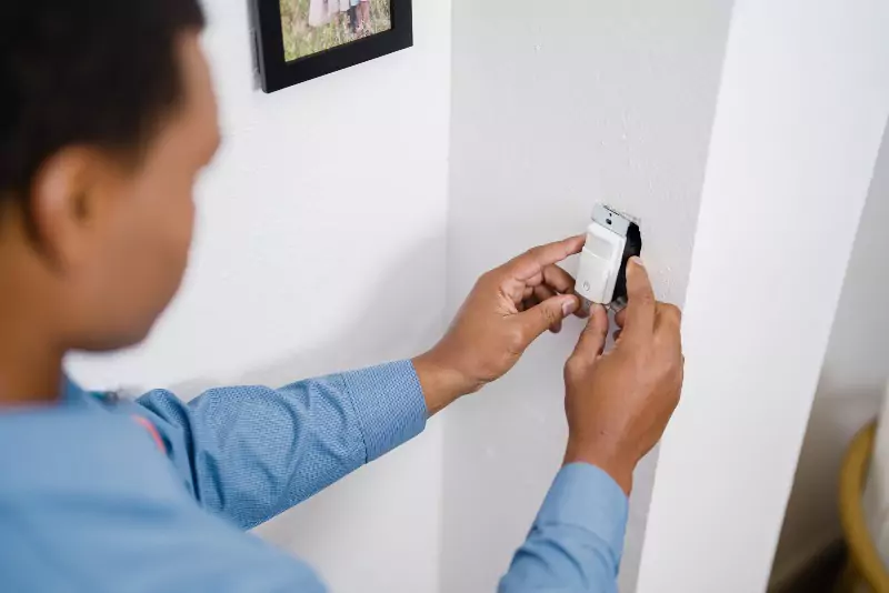 A Mr. Electric of the Coastal Empire electrician installing a light sensor in Savannah, GA.