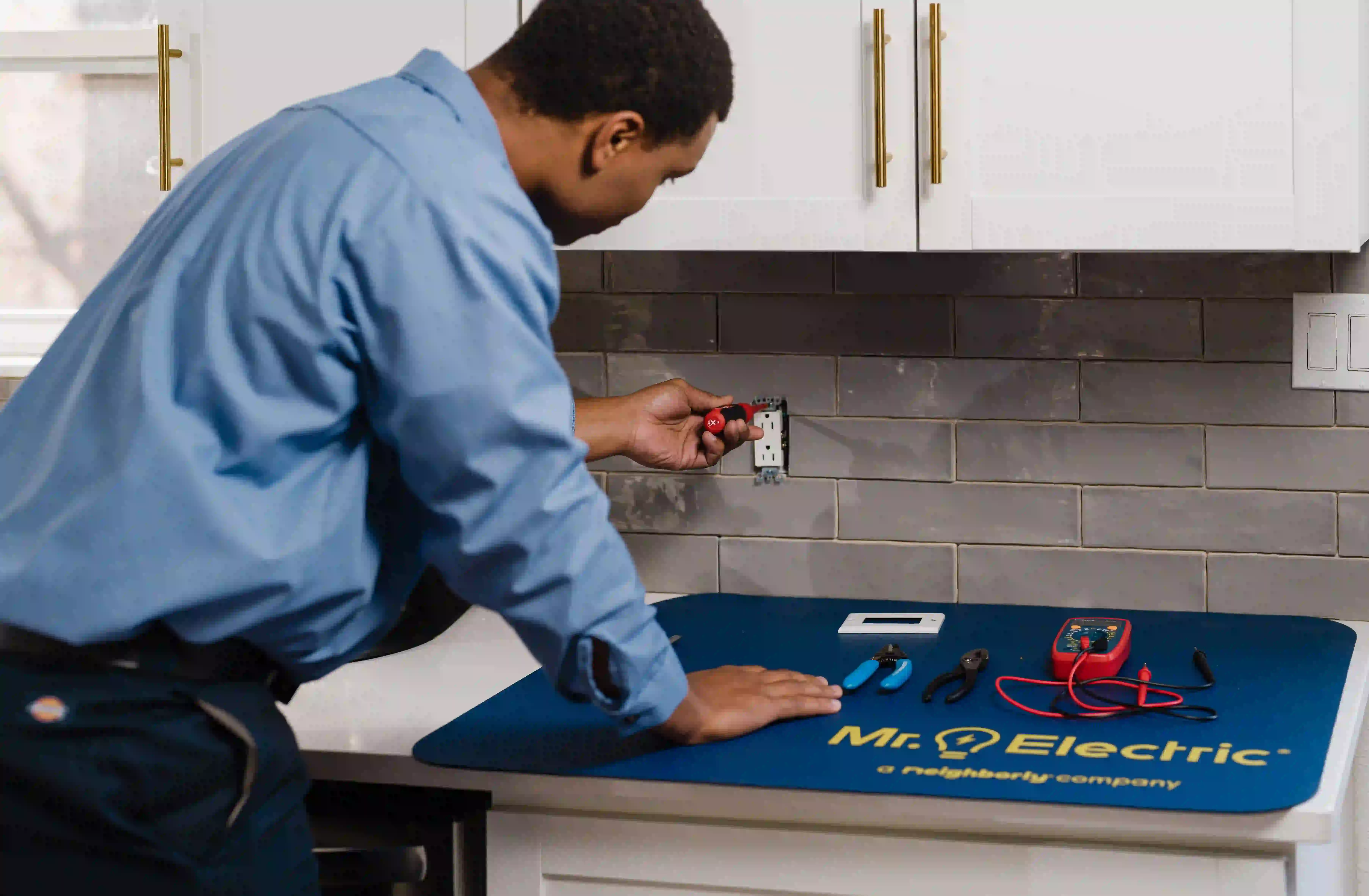 Mr. Electric electrician installing an electrical outlet